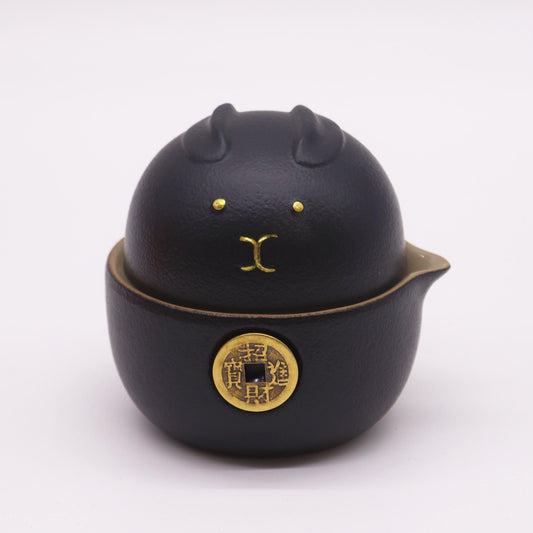 Black cat-shaped teapot with gold accents on a white background