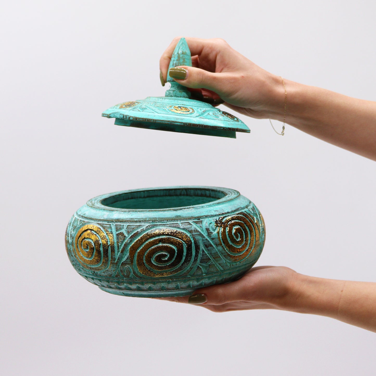 Side angle showcasing gold swirl details on turquoise finish being held open