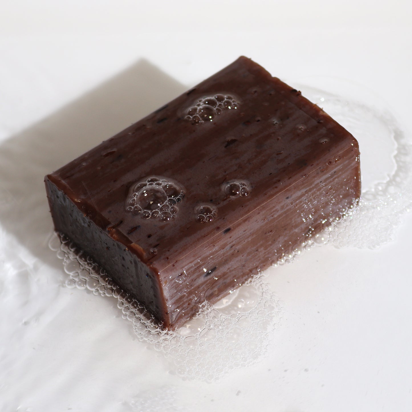 Exposed soap bar on white background with bubbles. 