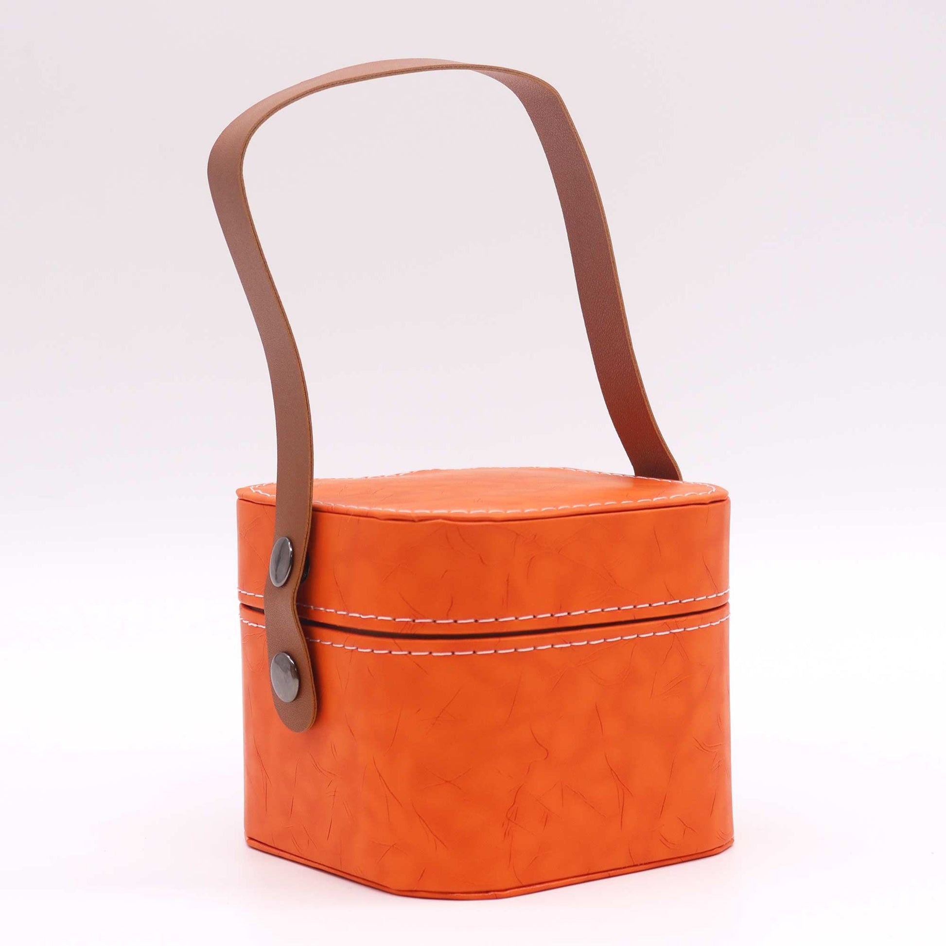 Orange fabric basket with a brown leather handle on a white background