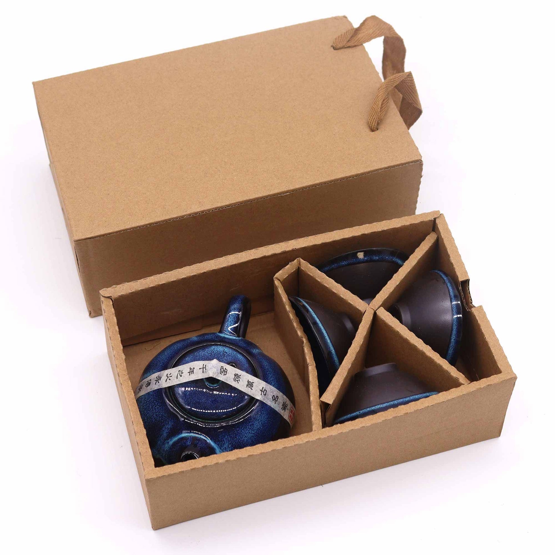 Blue ceramic teapots in a cardboard box on a white background