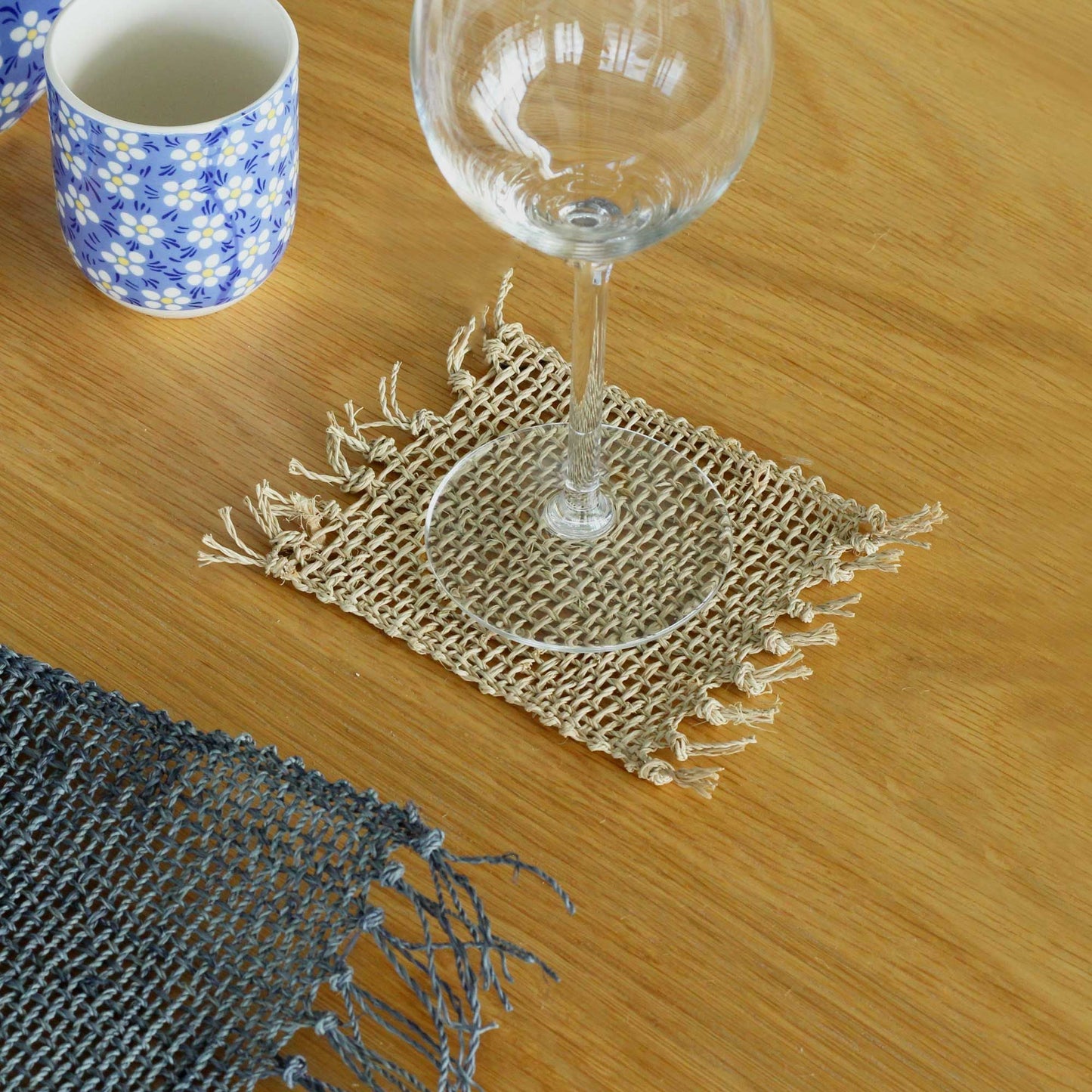 Square natural seagrass fringe coasters included in the Rainy Window Ritual