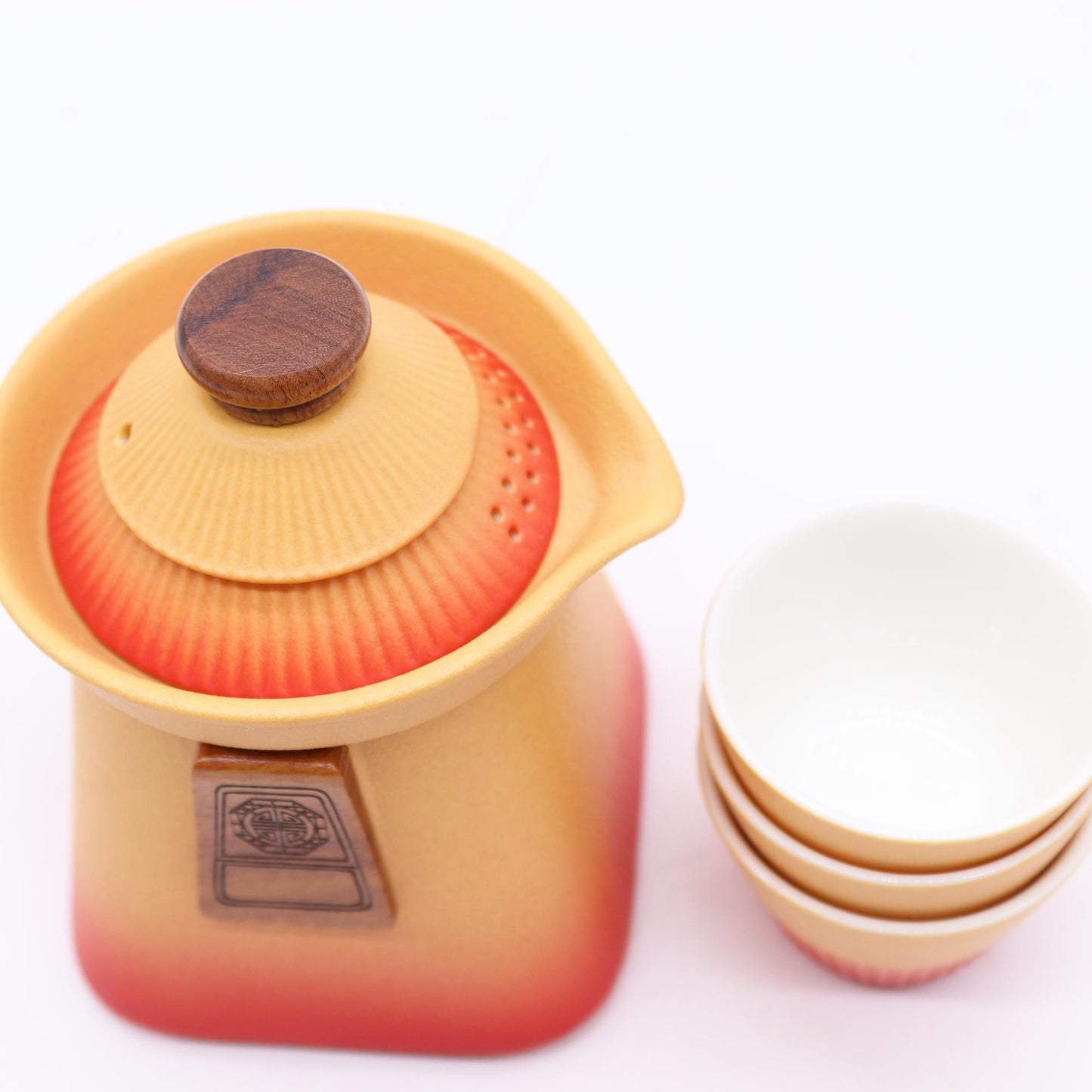 Yellow teapot with wooden lid and pink gradient, surrounded by white bowls on a white background