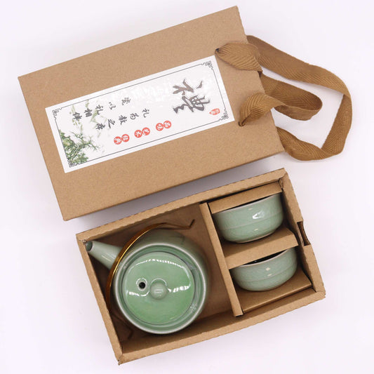 Green ceramic teapot and cups in a brown gift box with a decorative label.