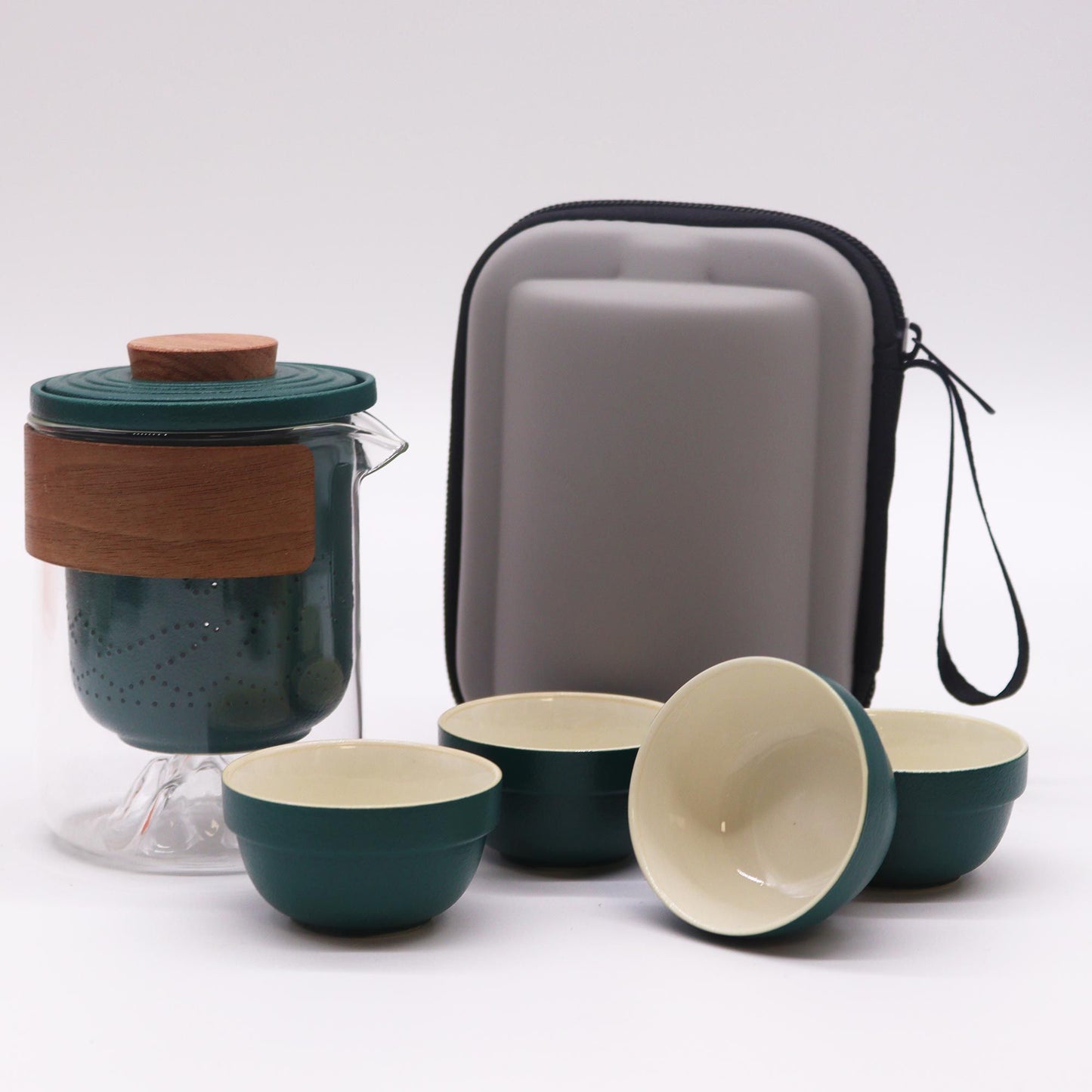 Set of green and beige ceramic bowls with a glass container and carrying case on a white background